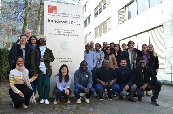 A group of young researchers is gathered in front of the Max Planck Institute for Meteorology in Bundesstraße, Hamburg.